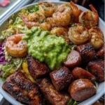 A loaded Cajun Surf and Turf Bowl topped with shrimp, sausage, chicken, and guacamole