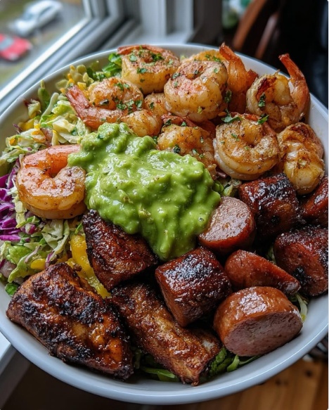 A loaded Cajun Surf and Turf Bowl topped with shrimp, sausage, chicken, and guacamole
