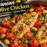 Mediterranean tomato olive chicken with cherry tomatoes, green olives, and fresh herbs.