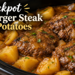Crockpot hamburger steak and potatoes in rich brown gravy with onions and fresh herbs